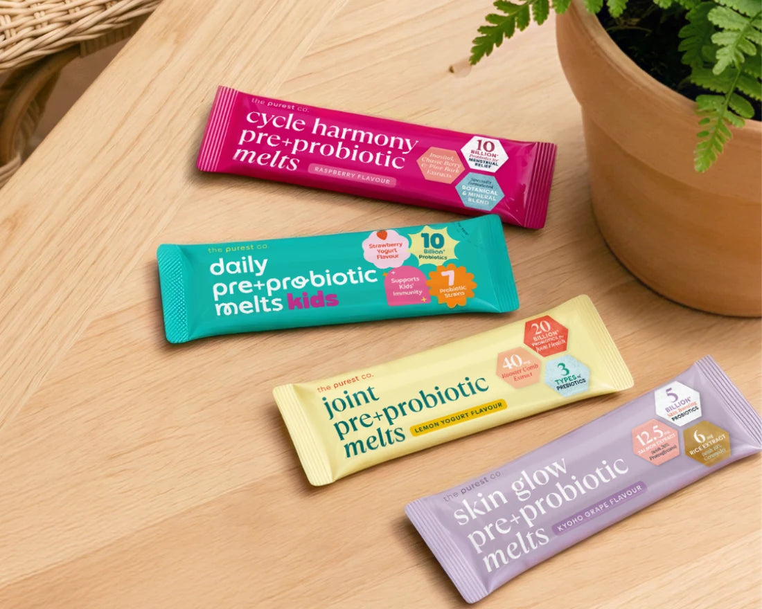 Four Pre+Probiotic Melts sachets laid out on a wooden table