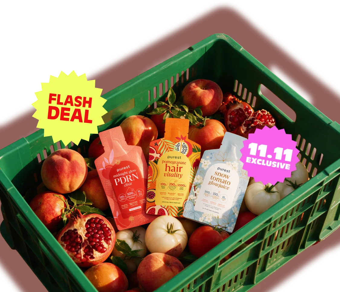 A green crate of peaches, pomegranates and white tomatoes with Midnight Glow PDRN Elixir, Pomegranate Hair Vitality and Snow Tomato Glowjuice sachets
