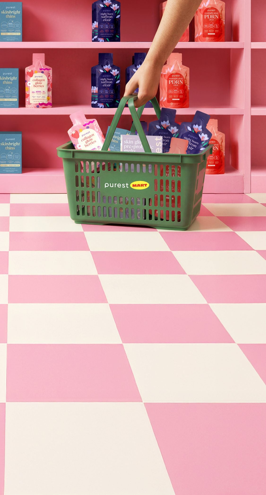 A hand picking up a green Purest Mart basket of Purest sachets in front of a pink shelf stocked with Skin Glow Pre+Probiotic Melts, SkinBright Thins, Night Burn Saffron Elixir and Midnight Glow PDRN Elixir